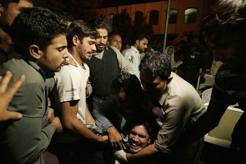 A Pakistani man comforted by others while mourning the death of a relative who was killed in suicide bomb attack in Wagah border near Lahore November 2, 2014. At least 45 people were killed on Sunday when a suicide bomber blew himself up on the Pakistani-Indian border, police said, just after a daily ceremony when troops from both sides simultaneously lower the two nations' flags. REUTERS