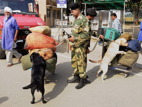 BSF jawans with sniffer dogs checking luggage of passengers at Attari international border on Monday. The security have been beefed up in the region after the Sundays suicide bomb attack at Wagah in Pakistan. PTI Photo