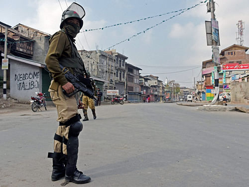 Ajawan stands guard during a curfewfollowing the killing of two youth allegedly inArmyfiring, in Srinagar onWednesday. PTI