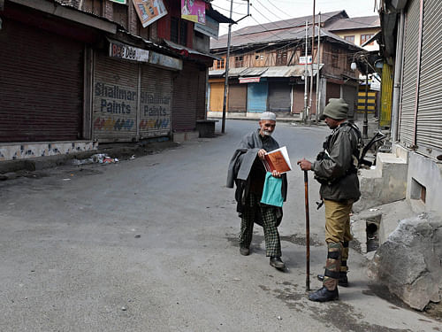An elderly person seeking permission from a security jawan during a curfew following the killing of two youth allegedly in Army firing, in Srinagar on Wednesday. Authorities imposed curfew in the view of protests over the killings. PTI Photo