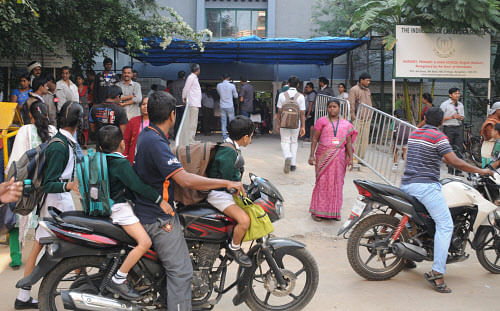 Back to school: Parents drop their children to school as the Indiranagar Cambridge School reopened on Thursday. DH Photo