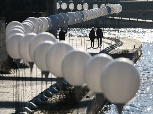 People walk between luminous white balloons along the former route of the Berlin Wall, in Berlin, Germany. Germany kicked off celebrations of the 25th anniversary of the epochal fall of the Berlin Wall Friday, set to culminate in rock stars and freedom icons joining millions at an open-air party. AP photo