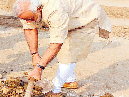 Prime Minister Narendra Modi wields a spade at Assi Ghat on Saturday. PTI
