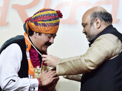 BJP President Amit Shah welcomes former National Confrence MLC from Jammu & Kashmir, Ajatshatru Singh as he joins the party at BJP headquarters in New Delhi on Sunday. PTI Photo