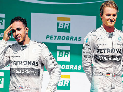 Mercedes' Lewis Hamilton (left)wears a concerned look while his team-mate Nico Rosberg savours his Brazilian Grand Prix victory at the Interlagos circuit on Sunday. AP