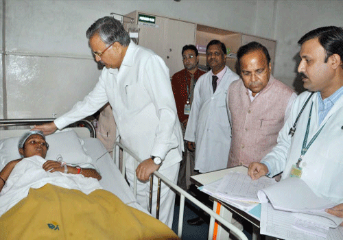 Chhattisgarh Chief Minister Raman Singh meets patients after a botched sterilization operation at a government camp left eight women dead and 30 others critical in Bilaspur on Tuesday. PTI Photo