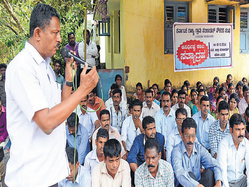 Karnataka State Gram Panchayat Workers' Association President K Yadav Shetty speaks during the indefinite strike of gram panchayat workers against the State government, in front of the Zilla Panchayat, at Kottara in Mangalore on Monday. CITU District General Secretary Vasanth Achary and others look on. Dh photo