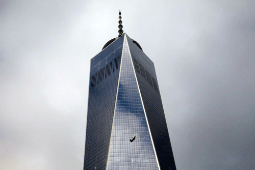 Stranded window washers hang on the side of 1 World Trade Center in New York November 12, 2014. New York City firefighters rescued the two window washers on Wednesday who had been trapped for two hours on broken scaffolding dangling outside the 69th floor of New York's tallest skyscraper, local officials said. REUTERS image