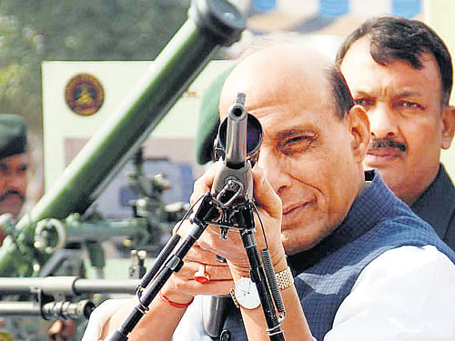 Home Minister Rajnath Singh inspects a weapon during Diamond Jubilee celebrations of Central Reserve Police Force at Kadarpur Group Centre in Gurgaon on Thursday. PTI Photo
