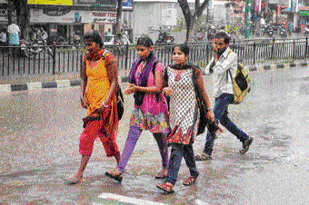 Unseasonal rain in Mysuru on Friday disrupted normal life but some people appeared to enjoy it. DH Photo