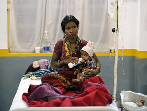 A woman, who underwent a sterilisation surgery at a government mass sterilisation camp, feeds her child while sitting on a hospital bed for treatment. Reuters photo