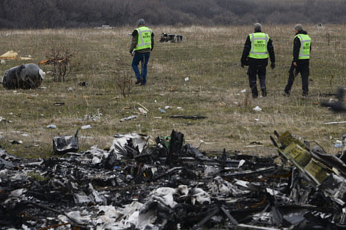 MH17 flight recovery team members examine one of the areas of the Malaysia Airlines Flight 17 plane crash in the village of Hrabove, Donetsk region, eastern Ukraine Tuesday, Nov. 11, 2014. AP photo