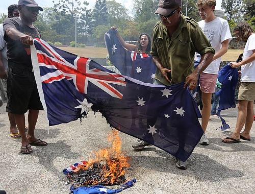 Aboriginal protesters burn an Australian flag during a rally in coincidence with the G-20 summit in Brisbane, Australia, Sunday. AP photo