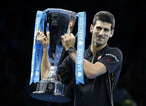 Novak Djokovic of Serbia raises the trophy after Roger Federer of Switzerland forfeited due to injury in the men's singles final at the ATP World Tour Finals at the O2 in London, November 16, 2014. Reuters photo