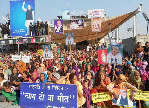 Followers sheild the Satlok Ashram of Sant Rampal in Hisar on Monday to resist his arrest. PTI Photo