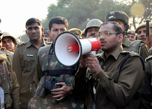 A police officer makes an announcement near the Satlok Ashram for the arrest of Sant Rampal in Hisar on Monday. PTI Photo