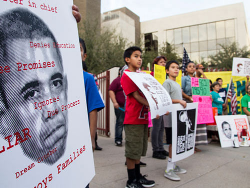 The activist group Puente, accompanied by family and friends facing deportation, holds a rally for deferred action for undocumented immigrants outside the U.S. Immigration and Customs Enforcement office in Phoenix on Friday, Nov. 13, 2014. AP file Photo