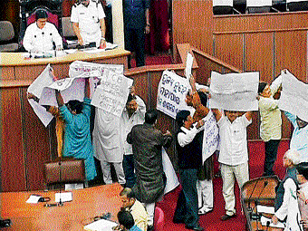 A video grab of MLAs of Congress and BJP showing placards in Odisha Assembly in Bhubaneswar on Thursday. PTI