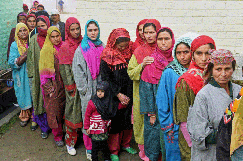 Women wait to cast their votes for Assembly elections at a polling station in Bandipora district of Jammu and Kashmir on Tuesday. 15 assembly segments went to polling in the first phase of elections in the state. PTI Photo
