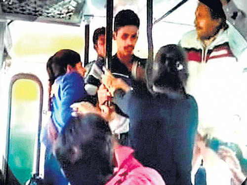 College girls beat up an eve-teaser with belts in a bus in Rohtak on Sunday. PTI Photo TV Grab