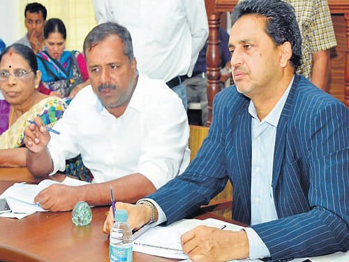 Minister for Health and Family Welfare U T Khader speaks at a press conference  in Mangaluru on Tuesday. DC A B Abrahim looks on. DH Photo