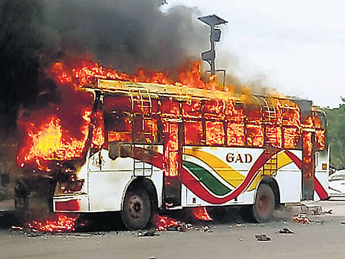 A private bus went up in flames after it rammed a median near Vengayyanakere at KR Puram on Tuesday. DH photo
