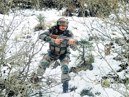 A soldier takes position during an encounter with militants at Nowgam in Kupwara district on Tuesday. PTI