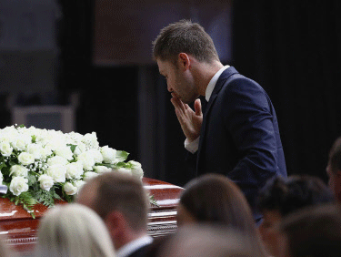 Australian cricket captain Michael Clarke pays his respect to Phillip Hughes at his coffin during his funeral in Macksville, Australia, Wednesday, Dec. 3, 2014. Hughes died last Thursday, two days after he was hit in the head during a domestic cricket match. AP Photo