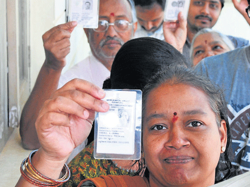 Voters queue up to cast their ballot, in Mysuru. DH photo