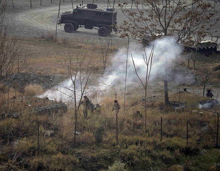 Indian army soldiers search for suspected militants as smoke rises from a bunker after a gunbattle at Mohra, in Uri December 5, 2014. Five members of the Indian security forces were killed in a suicide attack on an army artillery camp in northern Kashmir early on Friday as militants step up violence in the disputed region near the border with Pakistan, officials said. REUTERS
