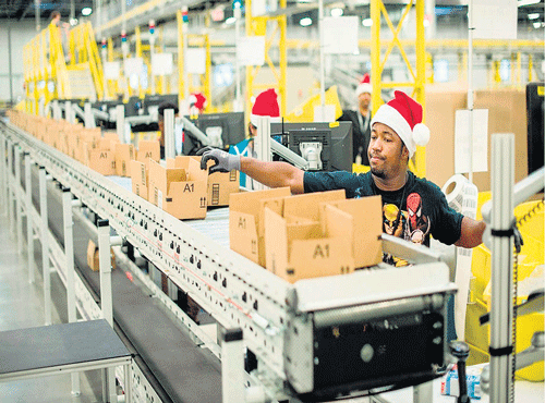 Workers pack items at anAmazon Fulfillment Center, ahead of the Christmas rush, in Tracy, California lastweek. The company, nowin its 20th year, has reported increasing losses. REUTERS