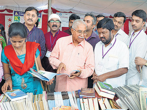 Jnanapith awardee Chandrashekhara Kambara and poet Siddalingaiah browse through books at the 'Pustaka Parishe' at Basavanagudi National College Grounds on Sunday. DH PHOTO