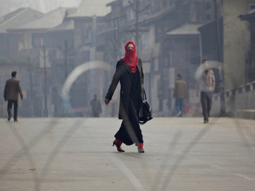 A woman walks on a deserted street during a curfew in Srinagar. Normal life was affected in Kashmir due to a strike called by separatist groups today, even as the authorities imposed restrictions in some parts of the city in view of Prime Minister Narendra Modi's maiden election rally in the valley. AP photo