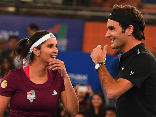 Micromax India Aces players Sania Mirza and Roger Federer during their mix doubles match against Singapore Salmmers at the International Premier Tennis League (IPTL) at IGI stadium in New Delhi on Sunday. PTI Photo