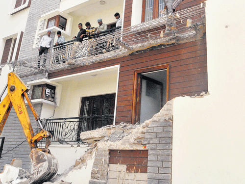 BBMP workers demolish the apartment constructed illegally on Richmond Road on Tuesday.