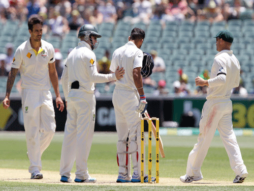Virat Kohli, is checked by Australia's Mitchell Johnson, Steve Smith and David Warner, after Kohli was hit on the head with a bouncer from Johnson during the third day of their cricket test match in Adelaide. AP photo