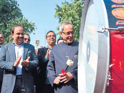 President Pranab Mukherjee beats a drum at the inauguration of Financial Literacy Centre at President's Estate in New Delhi on Thursday. PTI