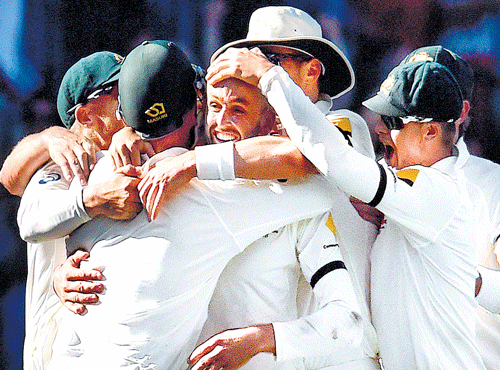 Australian playersswarmaround Nathan Lyon (centre) after the off-spinner dismissed India's Ishant Sharma to complete a 48-run win in the first Test at Adelaide on Saturday. AFP