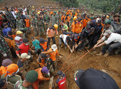 Rescuers try to pull out the body of a victim of a landslide that swept away a village in Jemblung, Central Java, Indonesia, AP file photo