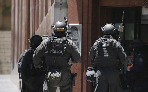 Heavily armed police stormed Sydney's Lindt Cafe where gunman has been holding hostages for the last 16 hours. AP Photo