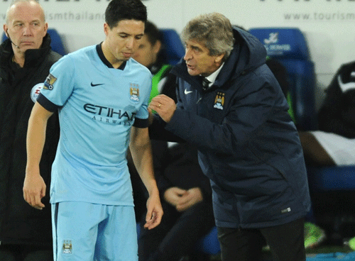 Manchester City's manager Manuel Pellegrini, right, gives instructions to Samir Nasri. File AP image