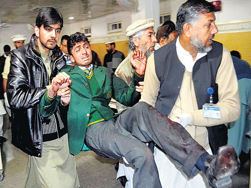 Attack aftermath: Pakistani volunteers carry an injured student at a local hospital in Peshawar on Tuesday. AP Photo