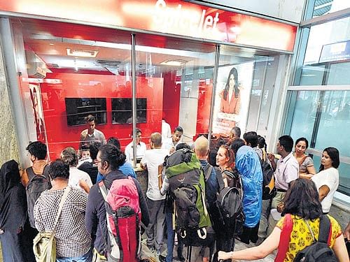 Passengers gather outside a SpiceJet booking counter at Mumbai domestic airport seeking refund and status about their cancelled flights on Wednesday. PTI Photo