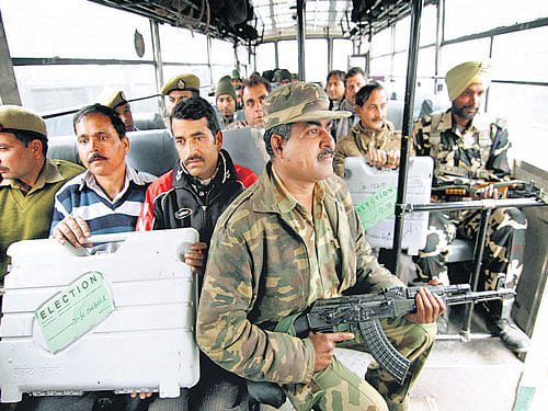 Paramilitary forces and polling officers with Electronic Voting Machines sit inside a vehicle as they leave for their respective polling stations ahead of the fifth phase of J&KAssembly elections inJammuon Friday. PTI