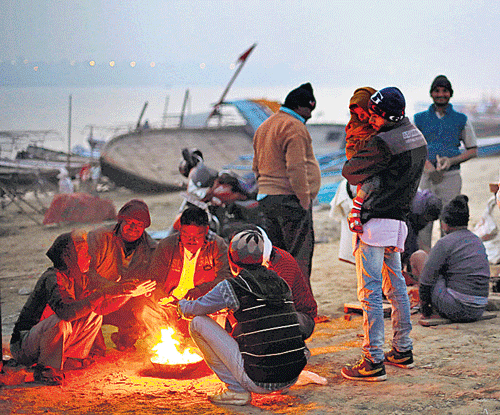 People keep warm around a bonfire on the banks of the  Ganga in Allahabad, Uttar Pradesh, on Saturday. AP Image . AP