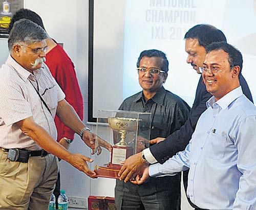 IXL 2014 champion Ramki Krishnan (centre) receives the trophy. DH Photo