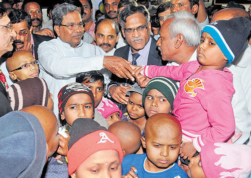 Chief Minister Siddaramaiah greets a child after inaugurating additional bed facility at the paediatric ward in Kidwai Memorial Institute of Oncology on Tuesday. dh photo