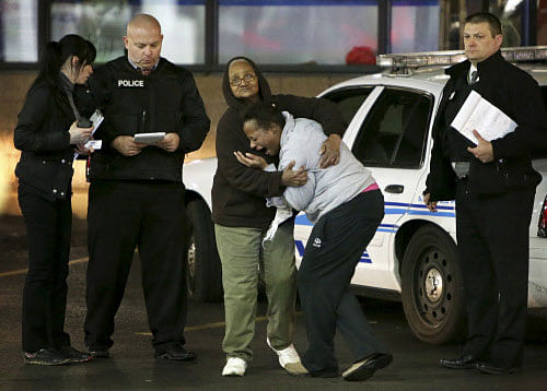 Toni Martin, front center, cries out on Wednesday, Dec. 24, 2014, as she talks to police at the scene where she says her son was fatally shot Tuesday at a gas station in Berkeley, Mo. Authorities did not immediately identify the man who was shot. But the St. Louis Post-Dispatch reported that Toni Martin, said he was her son, Antonio Martin. AP photo