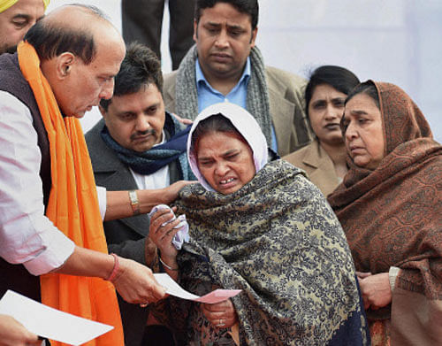 Union Home Minister Rajnath Singh presents a cheque to a riot widow during a meeting with families of 1984 Anti Sikh Riot victims, in Tilak Vihar widow colony, in New Delhi on Friday. PTI Photo