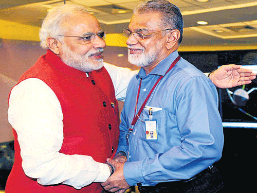 Prime Minister Narendra Modi congratulates ISRO Chairman Dr K Radhakrishnan after the success of the Mars Obiter Mission, in the City. DH file photo